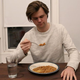 Noah Willson eats a bowl of beans in his kitchen.